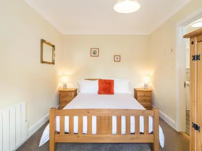 a bedroom with a bed and two night stands at Norbank Garden Studio in Bressingham