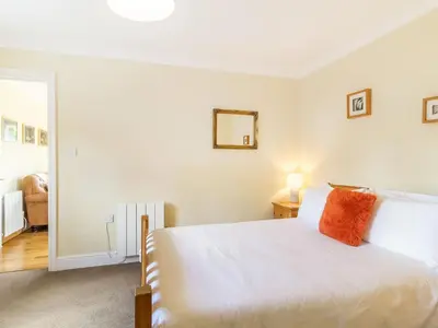 a bedroom with a white bed and a mirror at Norbank Garden Studio in Bressingham