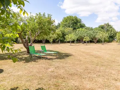 two green chairs and a table in a park at Norbank Garden Studio in Bressingham