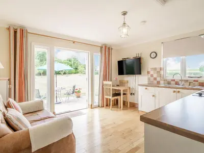 a kitchen and living room with a couch and a table at Norbank Garden Studio in Bressingham