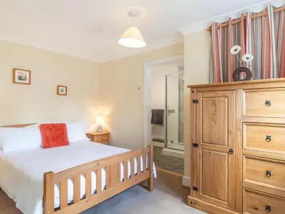 a bedroom with a bed and a dresser at Norbank Garden Studio in Bressingham