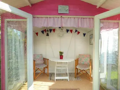 a porch with a table and chairs in a house at Spurling Cottage in Cheveley