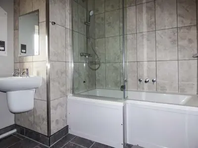 a bathroom with a shower and a tub and a sink at Glenhaven in Rendham