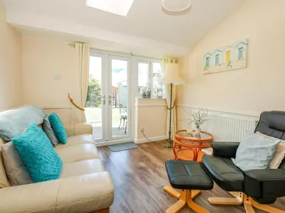 a living room with a couch and two chairs at Cameron's Cottage in Swaffham
