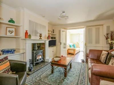 a living room with a fireplace and a couch at Cameron's Cottage in Swaffham