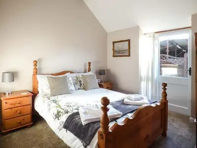 a bedroom with a bed and a dresser and a window at Stable View in Hingham