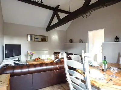 a living room with a leather couch and a table at Stable View in Hingham