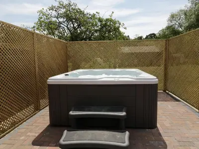 a bath tub sitting on top of a patio at Whitehands Farm Barn in Old Buckenham