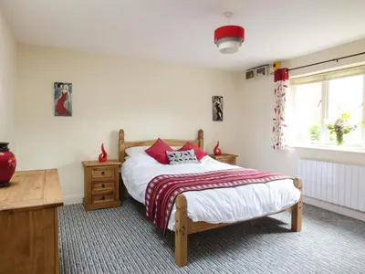 a bedroom with a bed and a table and a window at 27 Swan Street in Boxford