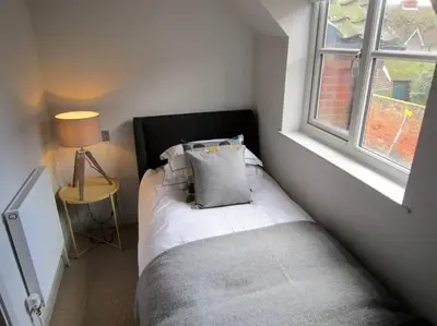 a bedroom with a bed with a pillow and a window at Crown Cottage, Orford - Prime Orford Location in Orford