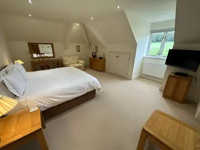 a bedroom with a bed and a television in it at Meadows Barn in Chelmsford