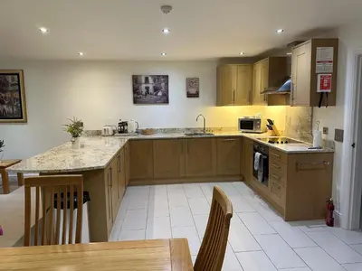 a kitchen with wooden cabinets and a counter top at Meadows Barn in Chelmsford
