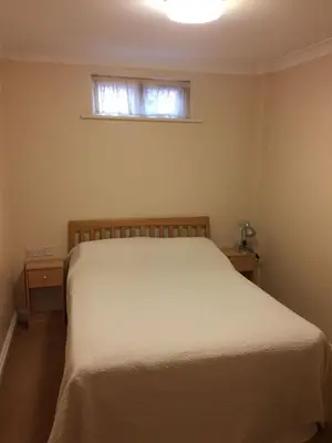 a bedroom with a white bed and a window at The Black Bull Inn in Fyfield