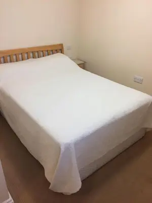 a bedroom with a white bed with white sheets at The Black Bull Inn in Fyfield