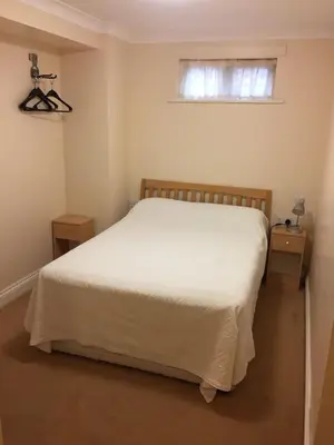 a bedroom with a white bed and a window at The Black Bull Inn in Fyfield