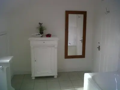 a bathroom with a mirror and a white cabinet at The Coach House in Shepreth