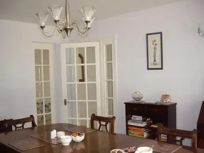 a dining room with a table and a chandelier at The Coach House in Shepreth