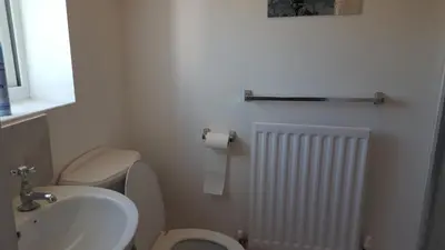 a bathroom with a white toilet and a sink at Haus Serviced Living in Braintree