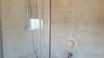 a shower with a glass door and a shower coil at Haus Serviced Living in Braintree
