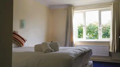 a bedroom with a large bed with a window at The New Chichester Hotel in Wickford