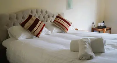 a white bed with a towel on top of it at The New Chichester Hotel in Wickford
