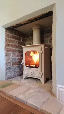 a white stove in a room with a fireplace at The Mill, Long Melford in Long Melford