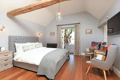 a bedroom with a bed and a desk and a chair at The Mill, Long Melford in Long Melford