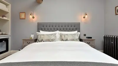 a bedroom with a large bed with white sheets and pillows at The Mill, Long Melford in Long Melford