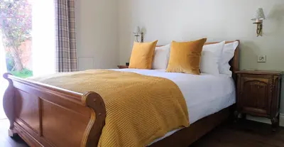 a bedroom with a large bed with yellow pillows at The Mill, Long Melford in Long Melford