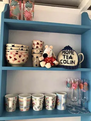 a teddy bear sitting on a shelf with cups at Campion Lodge in Chappel