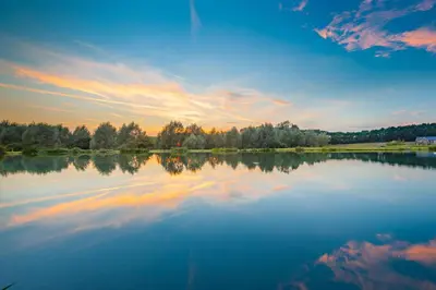 a large body of water with a sunset in the background at Woodbell Lodge in Chappel