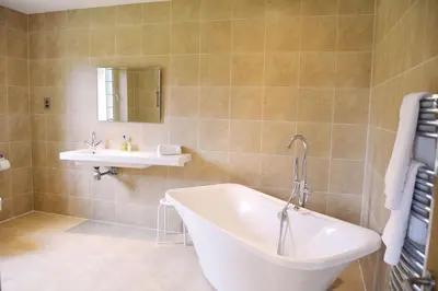 a bathroom with a tub and a sink at Woodbell Lodge in Chappel