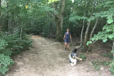 a woman and a dog walking down a trail at Woodbell Lodge in Chappel