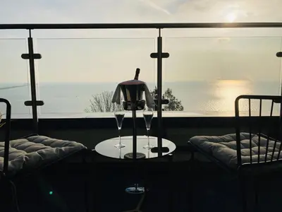 a table with two wine glasses on a table in front of a window at Seven Hotel in Southend-on-Sea
