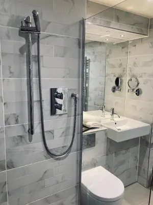 a bathroom with a shower and a toilet and a sink at Seven Hotel in Southend-on-Sea