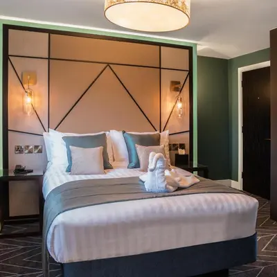 a bedroom with a large bed with a large headboard at Seven Hotel in Southend-on-Sea
