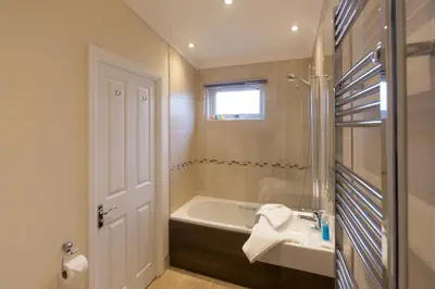 a bathroom with a bath tub and a sink at Sole Bay View in Sizewell