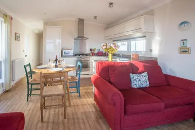 a living room with a red couch and a table at Sole Bay View in Sizewell