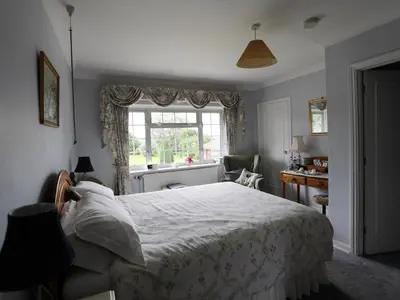 a bedroom with a large bed and a window at Newmans Hall Bed & Breakfast in Little Waldingfield
