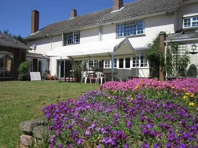 a house with purple flowers in the yard at Newmans Hall Bed & Breakfast in Little Waldingfield
