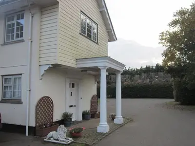 a house with a porch with two white columns at Newmans Hall Bed & Breakfast in Little Waldingfield