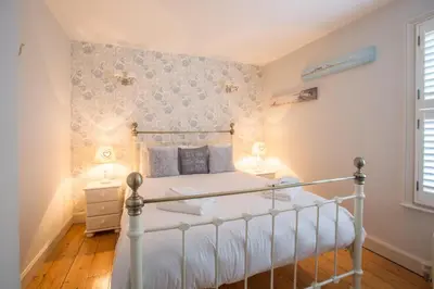 a bedroom with a bed with a white bed frame at Pugwash in Aldeburgh