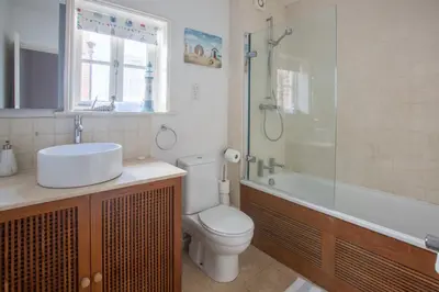 a bathroom with a toilet and a sink and a shower at Pugwash in Aldeburgh
