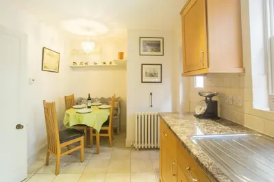 a kitchen with a table and a dining room at Pugwash in Aldeburgh