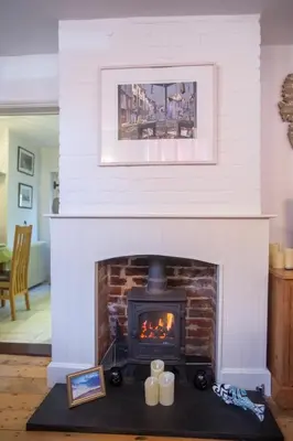 a living room with a fireplace with candles on a table at Pugwash in Aldeburgh