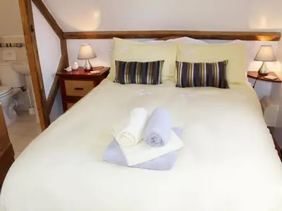a bedroom with a white bed with towels on it at The Hayloft in West Bradenham