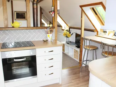 a kitchen with white cabinets and a stove top oven at The Hayloft in West Bradenham