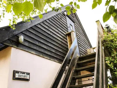 a staircase leading up to the door of a house at The Hayloft in West Bradenham