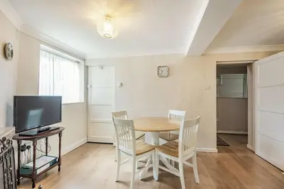 a dining room with a table and chairs and a television at Violet Cottage in Feltwell