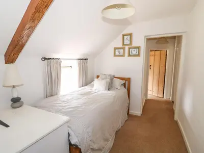 a bedroom with a white bed and a window at Manor Farm Cottage in Swaffham